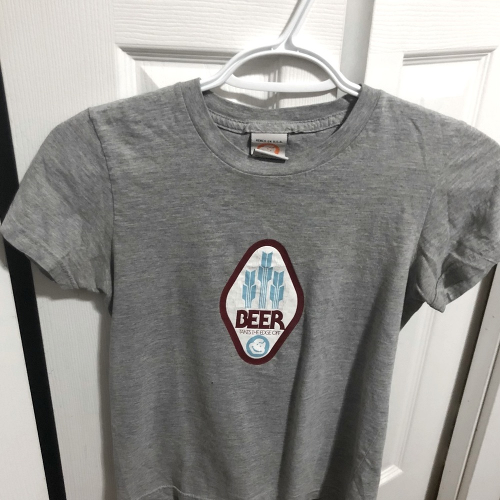Small grey Jeenyus t-shirt. Says “Beer takes the edge off”
